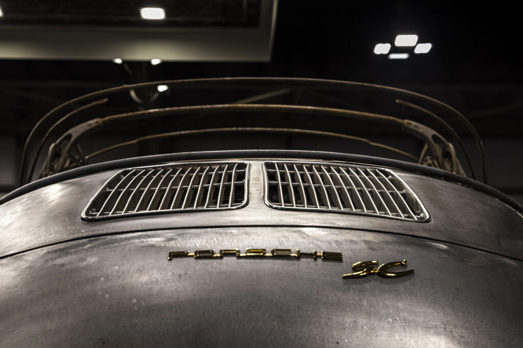 Aces Auto Elite - Low-angle view of the rear of a vintage Porsche car, highlighting metallic paint, ventilation grilles, and gold Porsche 2C lettering. The soft indoor lighting showcases meticulous restoration and preservation of classic details. | Arizona Luxury & Exotic Car Service